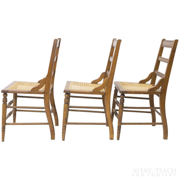 Side view of three of the American Sheraton chairs with cane seats.