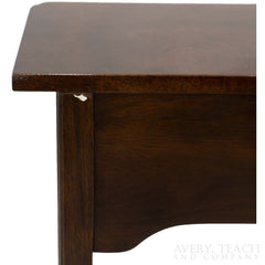 A close up of the back left corner of a vintage Stickley end table.