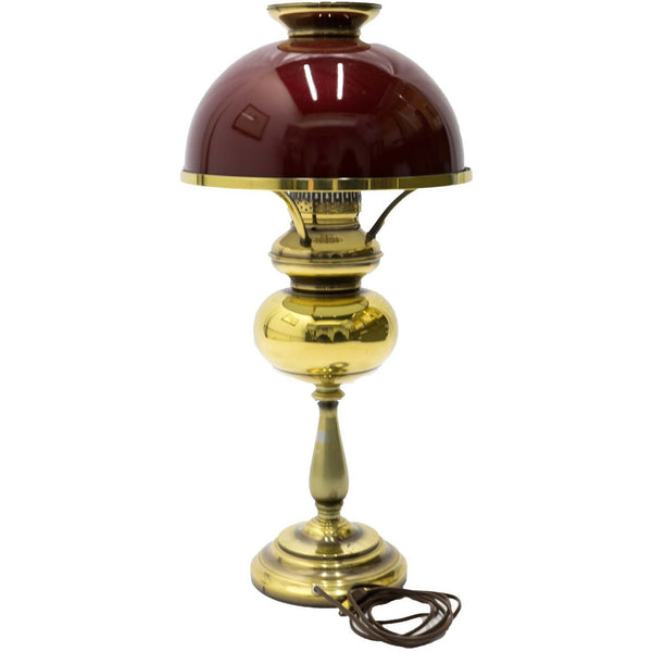 A vintage hurricane lamp with a dark red shade and golden base.