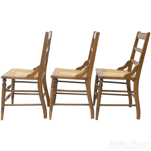 Side view of three of the American Sheraton chairs with cane seats.