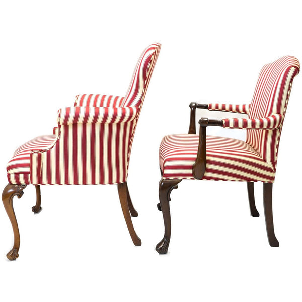 Side view of a pair of red and white striped parlor chairs.