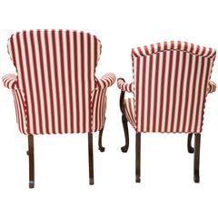 Back view of a pair of red and white striped parlor chairs.